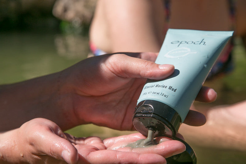 Hand squeezes NU skin mud mask out of the tube.
