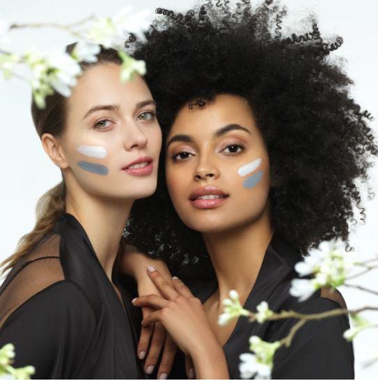 Two young women with Yin and Yang face mask by Nu Skin