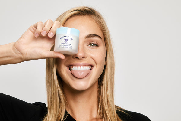 Woman holds Moisturize Me Intense Hydrating Cream can